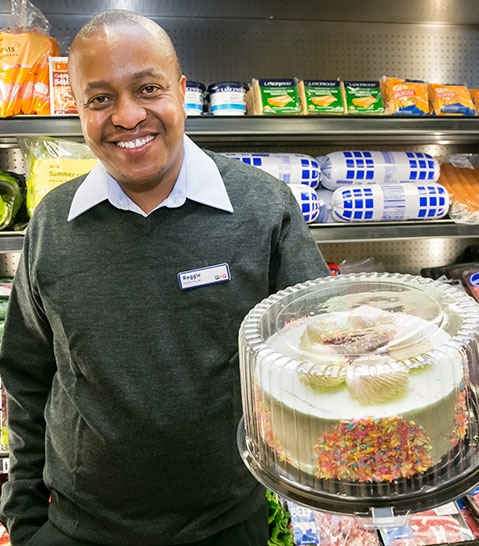Grocery store employee holding a birthday cake