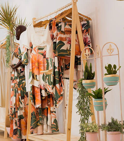 A clothing rack with plants around them
