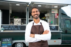 Food truck man smiling in front of his business 