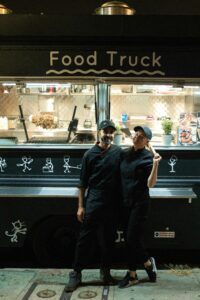 Cooks in front of a food truck 